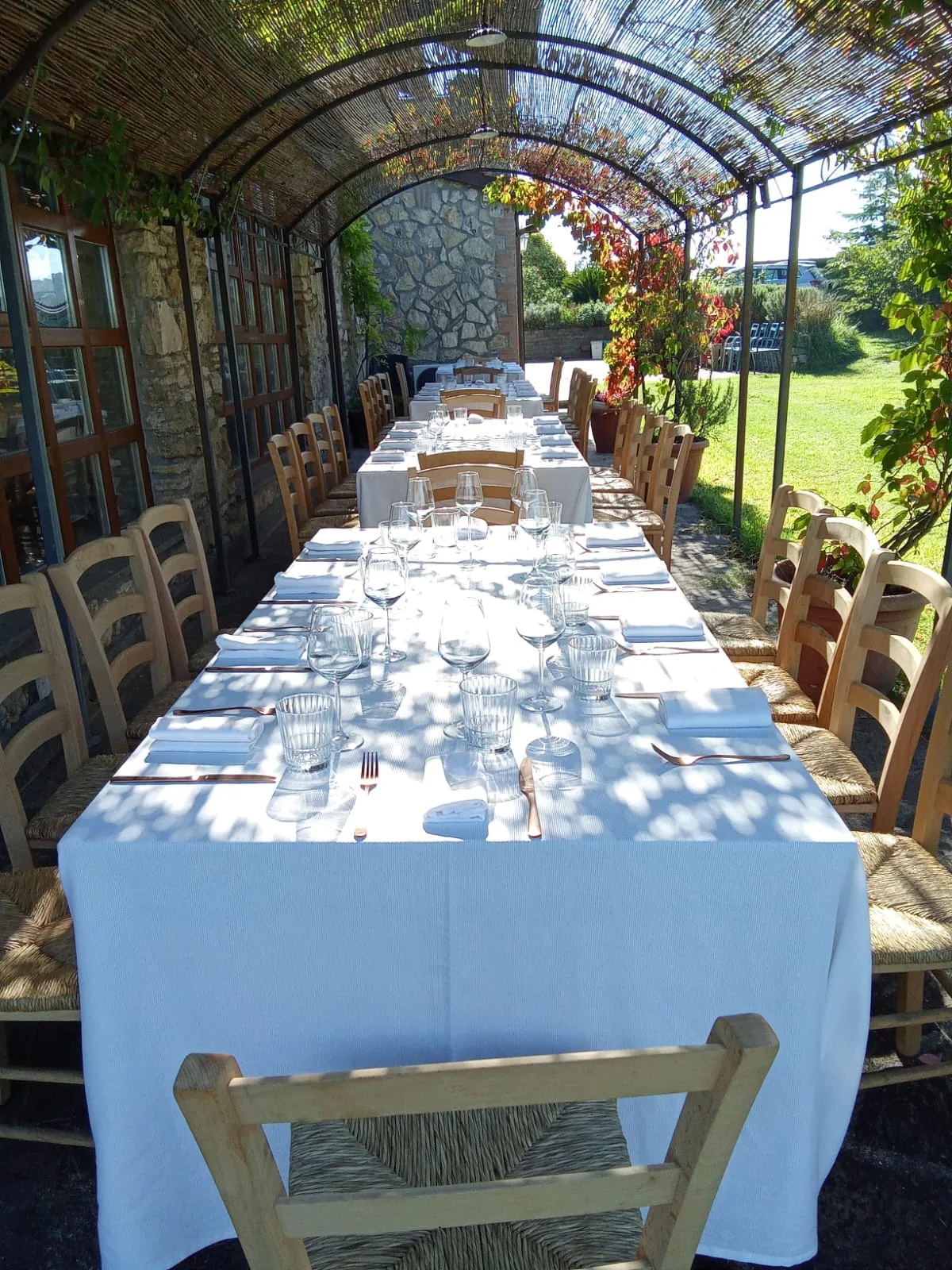 Tavolata all'aperto sotto la pergola di Tuscia Prestige